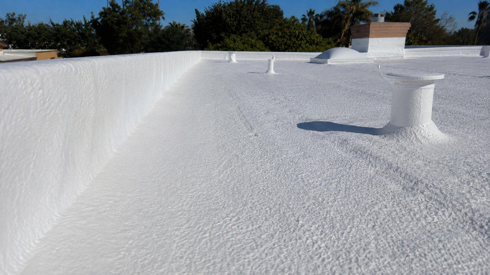 Seamless foam coating running up a parapet wall